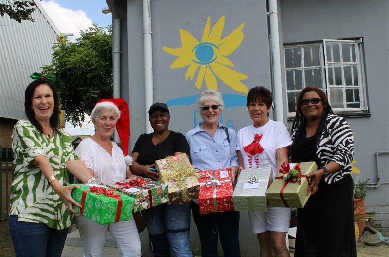 Group of women holding Christmas gifts