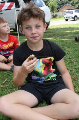 White boy wearing a black shit sitting on the grass