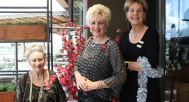 An elderly woman and two others pose for a photo