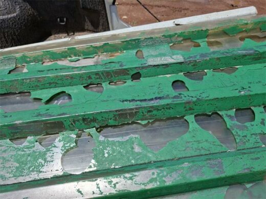 Three people working on a corrugated steel structure