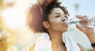 Brown woman drinking water from a bottle