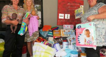 Women standing with gifts and donations