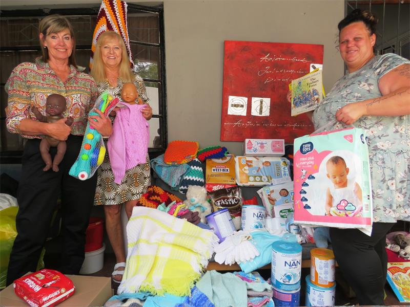 Women standing with gifts and donations