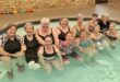 Twelve women sitting in a pool
