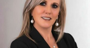 Woman with blonde hair wearing a black jacket