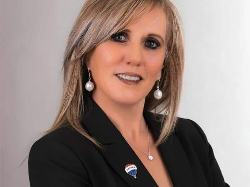 Woman with blonde hair wearing a black jacket
