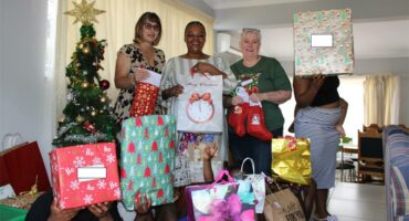 Three women standing with a group of children