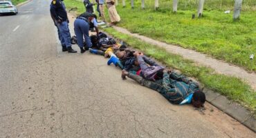 Group of men lying on the road
