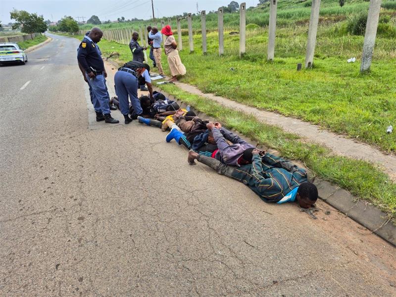 Group of men lying on the road