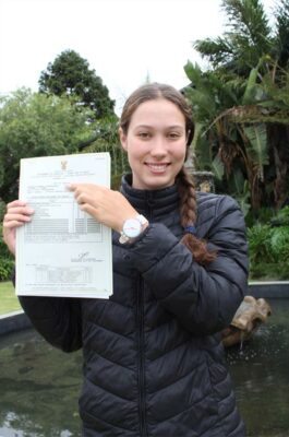 Meisie staan met 'n papier in haar hand