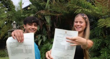 Seun en meisie hou papiere voor hulle