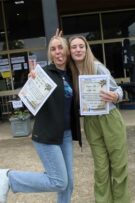 Twee meisies trek gesigte en hou koeverte vas