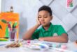 Brown boy sitting at a desk