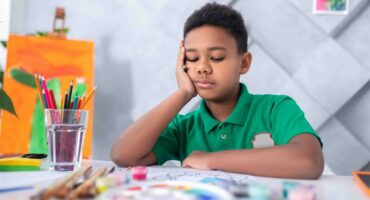 Brown boy sitting at a desk
