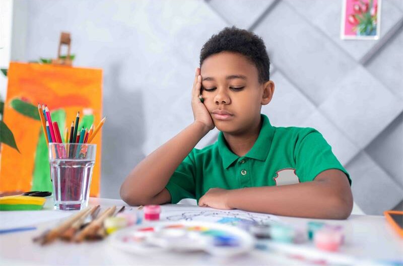 Brown boy sitting at a desk