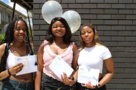 Three black girls holding envelopes