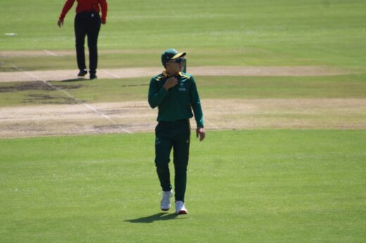 Man wearing a green sport's uniform and sunglasses