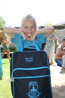 Blonde dogtertjie hou 'n skoolsak voor haar