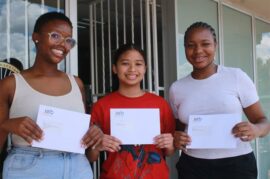 Three girls holding envelopes