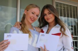 Two girls holding envelopes