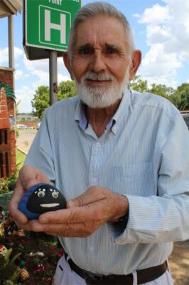 Old man holding a painted ladybug