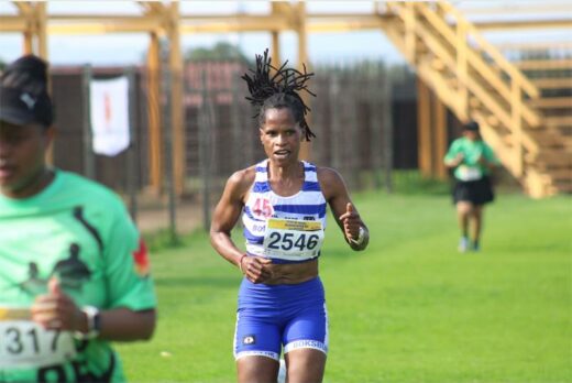 A photo of a runner in a blue and white vest and blue tights.