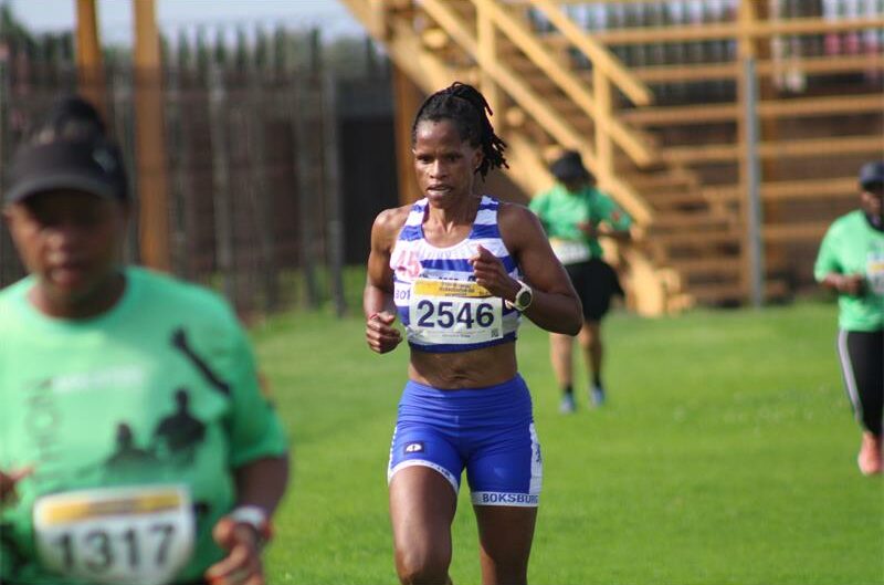 A photo of a runner in a blue and white vest and blue tights.