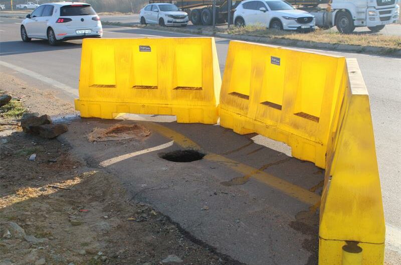 Yellow barriers placed around a hole