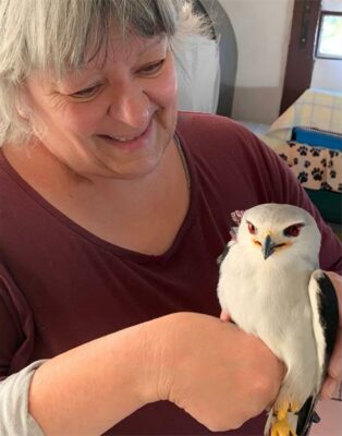 Woman holding a black and white bird