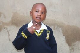 Black boy holding two fingers up