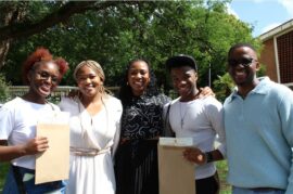 A group of black people with two holding envelopes