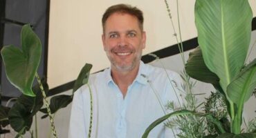 Man standing a display of plants