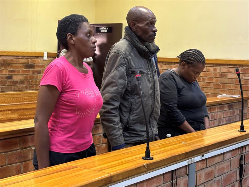 Three black people, two women and a man standing in court