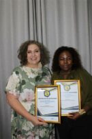 Two women holding certificates