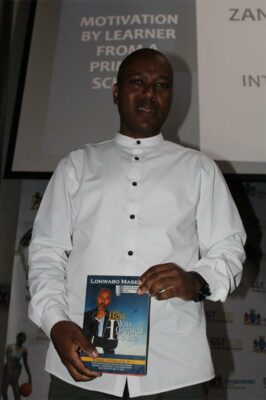 Black man with white shirt holding a book
