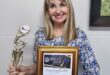 Vrou hou ‘n sertifikaat and trofeë