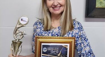 Vrou hou ‘n sertifikaat and trofeë