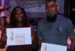 Black woman and Indian man holding envelopes