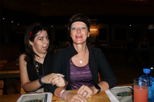 Two women in black at a wooden table