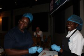 Two servers wearing blue gloves