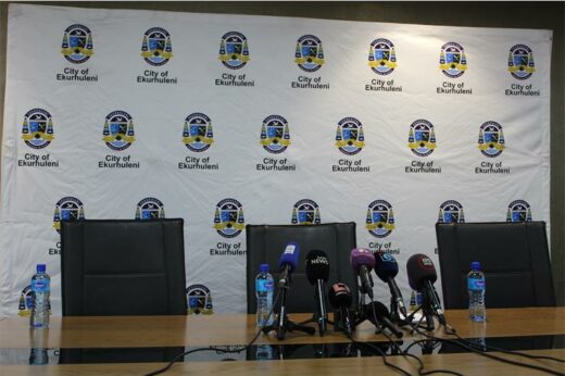 Three empty seats in front of a CoE banner