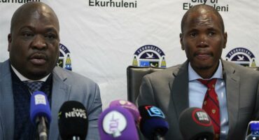 Two black men sitting in front of microphones