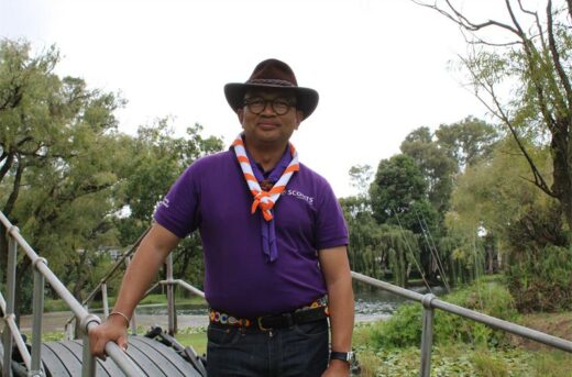 Asian man wearing a purple scouts shirt
