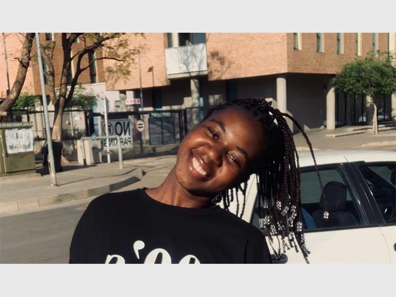 A lady smiling with her head tilted.