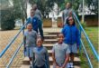 Group of black children wearing blue uniforms standing on steps