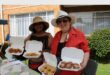 Indian and white woman holding baked goods