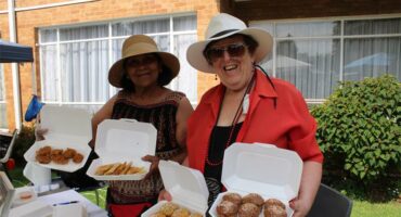 Indian and white woman holding baked goods