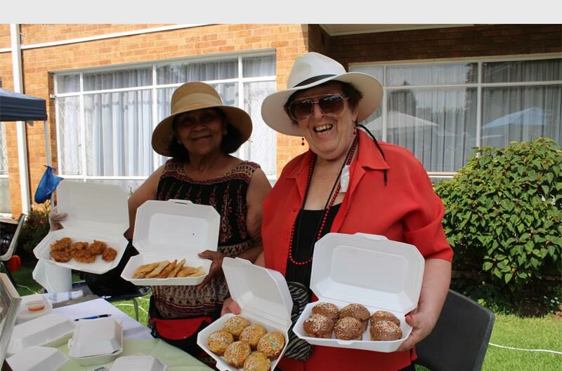 Indian and white woman holding baked goods