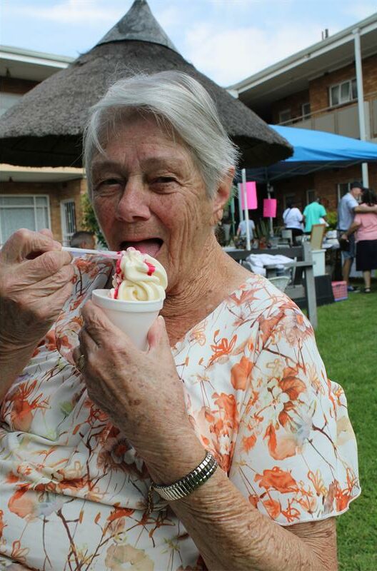 Elderly woman eating an ice-cream