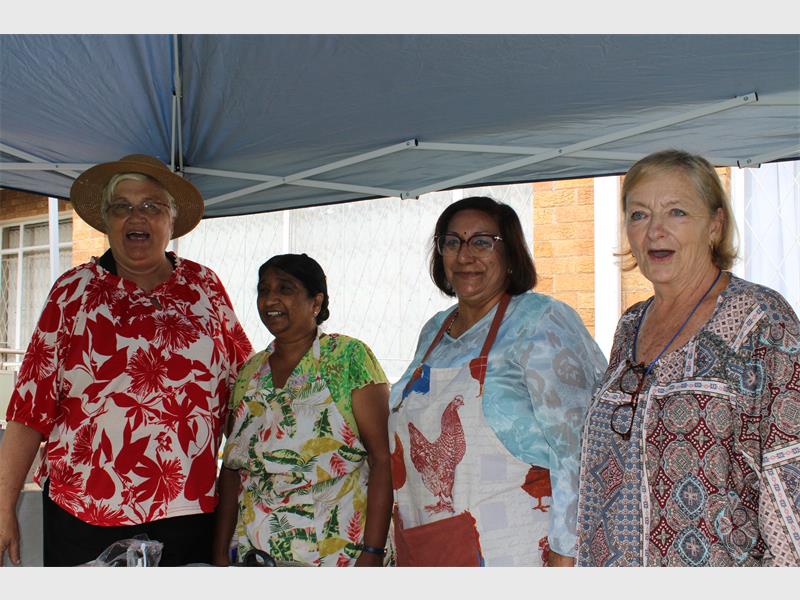 Four women, two white and two Indian standing next to each other